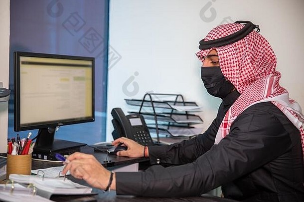沙特男人。穿面具作品办公室工作一天开放禁止电晕流感大流行