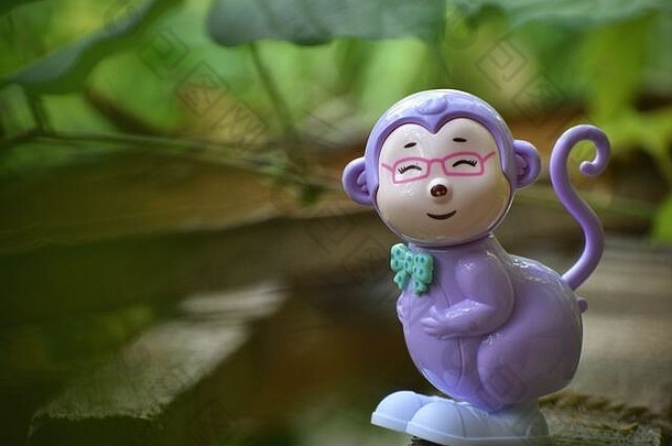 肖像微笑猴子玩具绿色背景模糊树叶