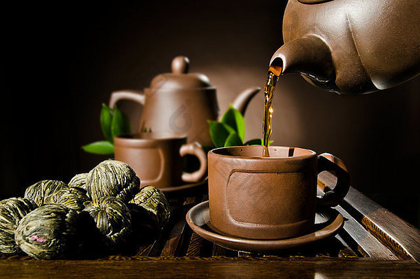 垂直照片粘土茶壶茶流杯棕色（的）背景茶仪式