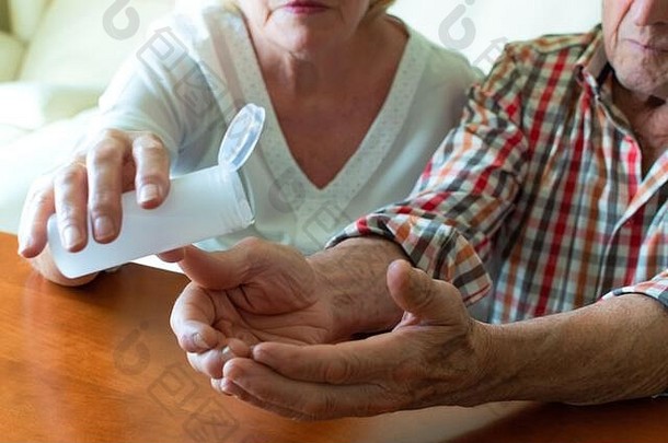一对老年夫妇在街上后在家里使用<strong>洗手液</strong>凝胶。保护老年人<strong>免</strong>受感染和冠状病毒。