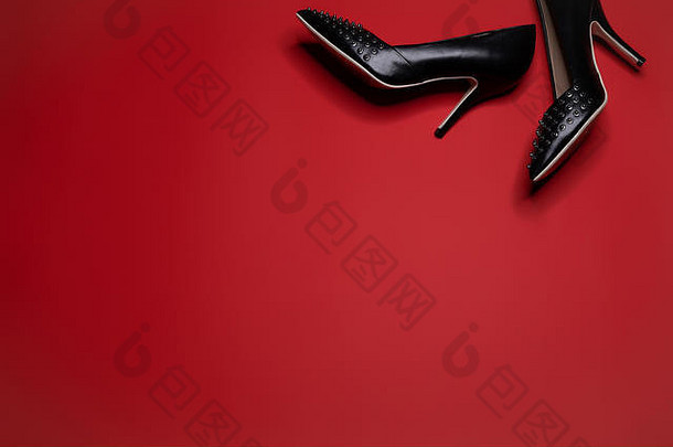 一双红色底色的黑色皮鞋，鞋钉和高跟鞋