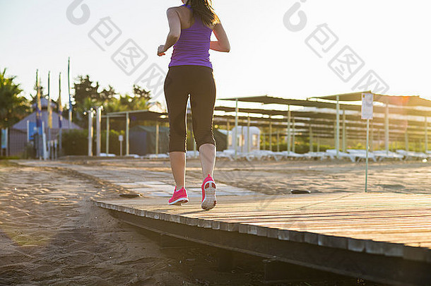 跑步的女人。女跑步者在码头上进行户外锻炼时慢跑。脚的细节。