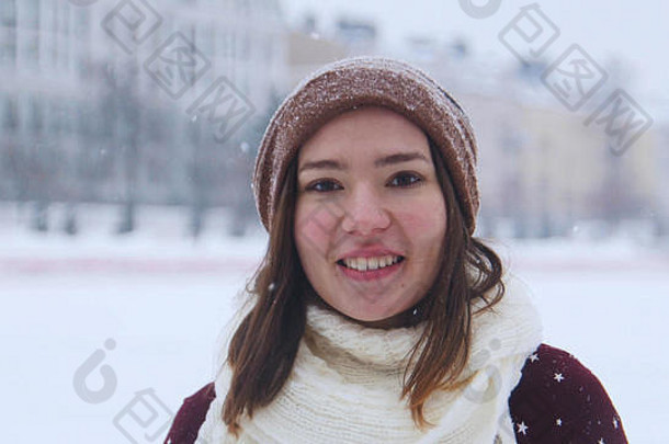 一个微笑的年轻女子站在冬天的外面。