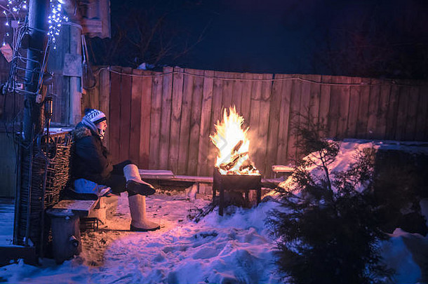 冬日沉思的孤独少年<strong>男孩</strong>在雪夜的乡村里失踪，在火中取暖