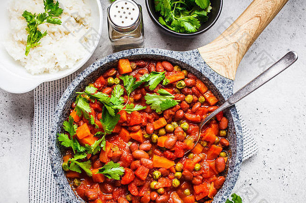 白<strong>底</strong>平<strong>底</strong>锅中炖有西红柿和米饭的纯菜豆。纯素食物概念。