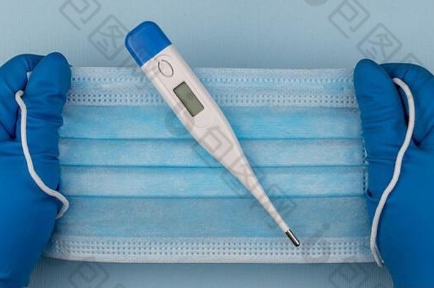 预防冠状病毒的外科口罩和测量体温的电子温度计。