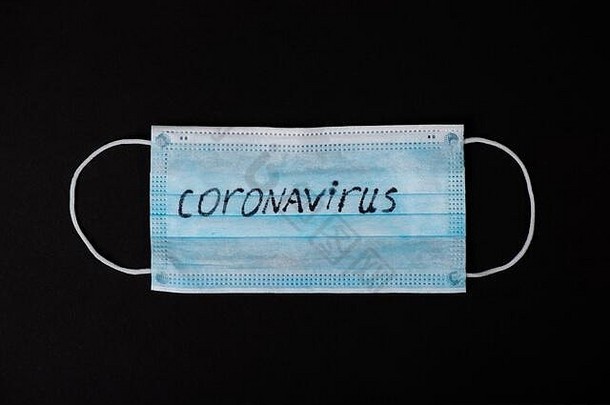 恐慌COVID2019冠状病毒疾病爆发概念。黑色背景的冠状病毒防护口罩
