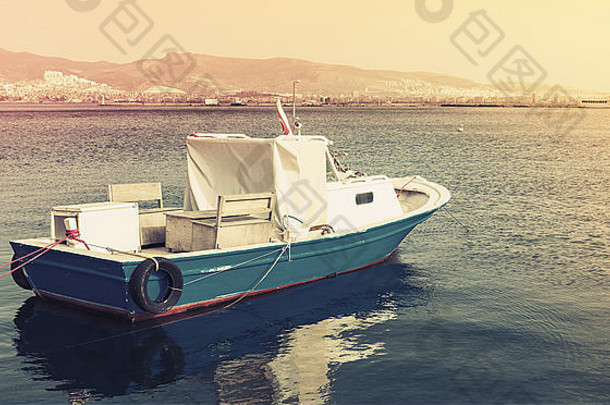 停泊在土耳其伊兹密尔湾的旧木制游艇。带有黄调校正照片滤镜的复古风格照片，old st