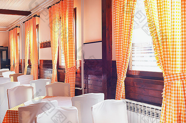 经典的餐厅内部，有趣的老式窗帘和白色家具。