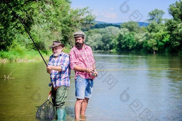 夏季周末。和平活动。接得好。杆和滑车。渔夫渔具。渔夫爷爷和成熟男人是朋友。父子钓鱼。渔夫家庭。爱好体育活动。