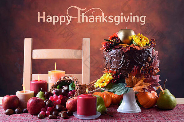 美丽的感恩节秋季餐桌，配有秋季主题巧克力蛋糕、聚宝盆和蜡烛。