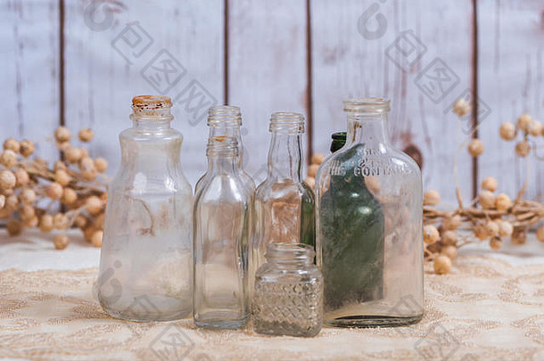 旧瓶子在木质背景前聚集在一起