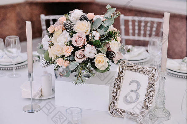 婚礼桌上的美丽柔情花束，烛台和数字