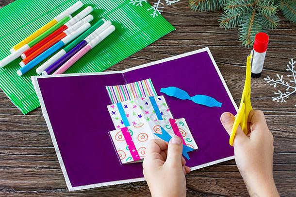 一个孩子用圣诞礼物剪下生日卡片的细节。手工制作的。儿童艺术项目，儿童手工艺。儿童手工艺。