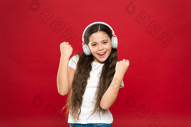 音乐品味。音乐在青少年的生活中起着重要的作用。音乐对青少年的情感、感知世界有着强大的影响。女孩戴着红色背景的耳机听音乐。现代小工具概念。
