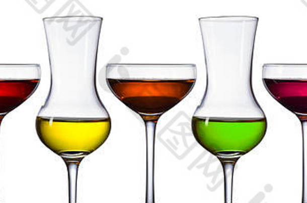 在白色背景上分离的不同酒精饮料的玻璃杯。蓝色、绿色、黄色、橙色和不同深浅的红色。