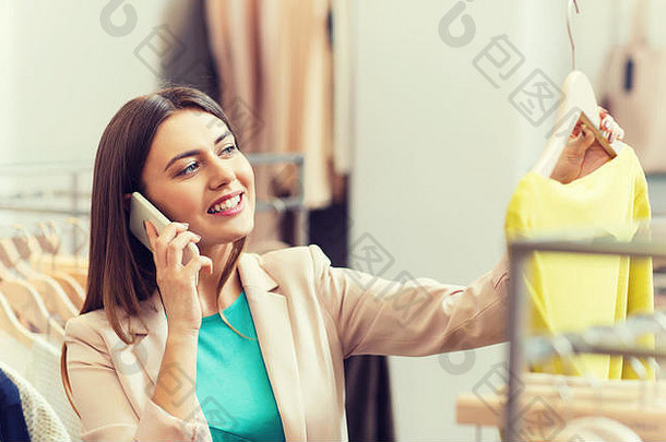 一位女士在服装店打电话给智能<strong>手机</strong>