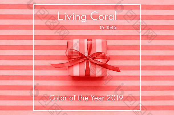 2019年度活<strong>珊瑚色</strong>礼品盒，带蝴蝶结的条纹包装纸。抽象几何背景。