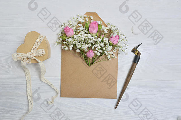 书法羽毛一个装有花、玫瑰和一封信的信封