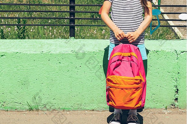 女孩明亮的衣服运动鞋粉红色的背包绿色墙学校概念水平框架