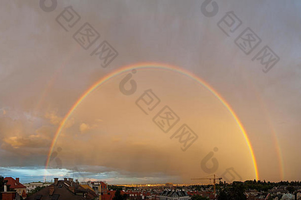 在奥地利维也纳城市天际线上方的一大片雷雨云中，夕阳产生了双彩虹。