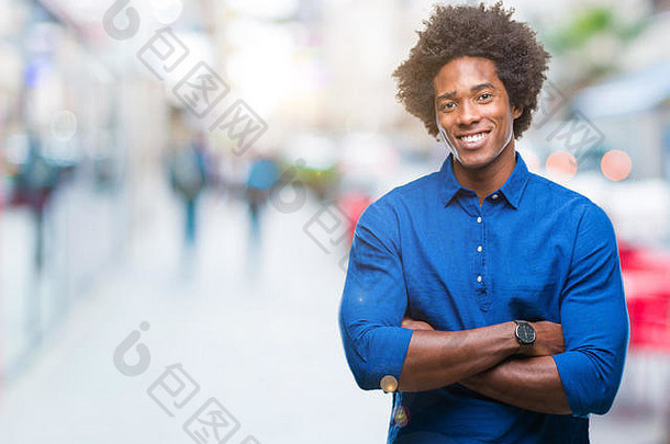 一名非裔美国人在孤立的背景下微笑着双臂看着摄像机。积极的人。