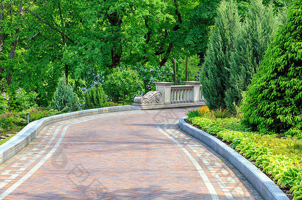 铺设平路径美丽的公园通过绿色草坪上装饰花框架国灌木保管妥当的树