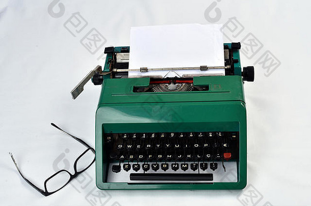 复古复古打字机，白色背景旁有纸和眼镜