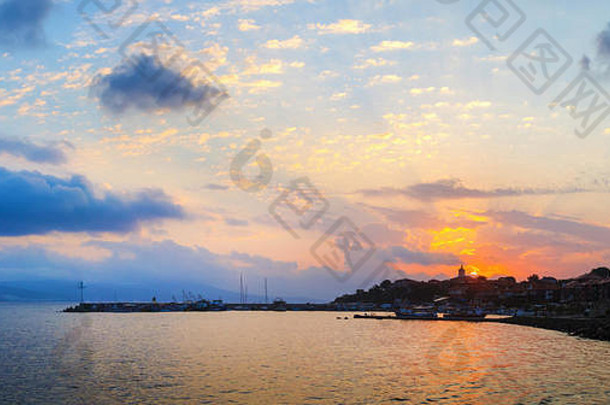 黑海海岸的日出。保加利亚内塞巴尔古城的海岸线。太阳在天空的背景上升起，伴随着积云。黎明时分