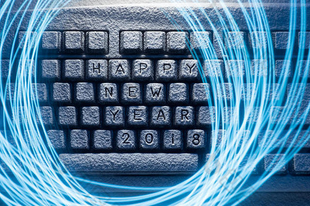 键盘上覆盖着白雪，刻有“2018年新年快乐”的字样，并涂有轻线