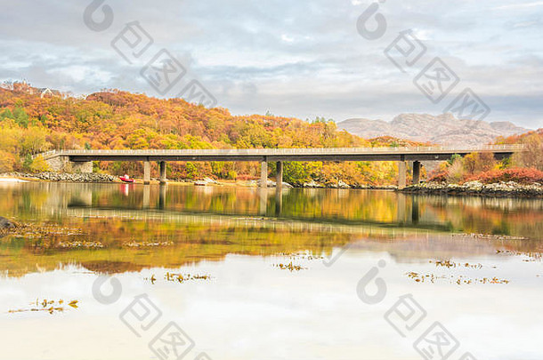 这座桥横跨苏格兰高地莫拉尔附近的莫拉尔河，承载着A830公路——秋天的景色，橙色的树叶和树木倒映在w