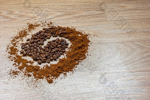 <strong>咖啡</strong>豆和磨碎的<strong>咖啡</strong>放在一张木制桌子上，像一个螺旋。风格概念