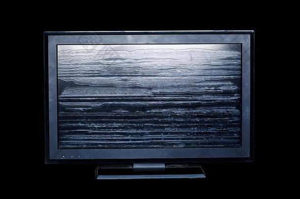 旧电视机的屏幕在黑色背景下破损。