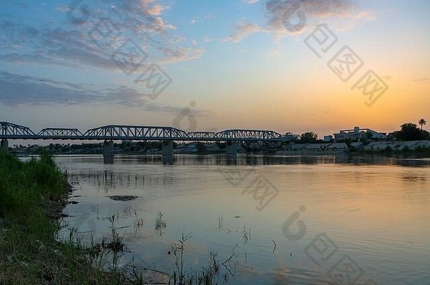 巴格达，伊拉克——2020年4月4日：伊拉克巴格达市日<strong>出照片</strong>，其中展示了萨拉菲亚大桥和底格里斯河，以及许多建筑物。