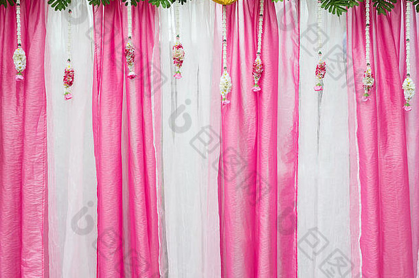 粉色和白色织物背景，带有婚礼上的新鲜花卉。