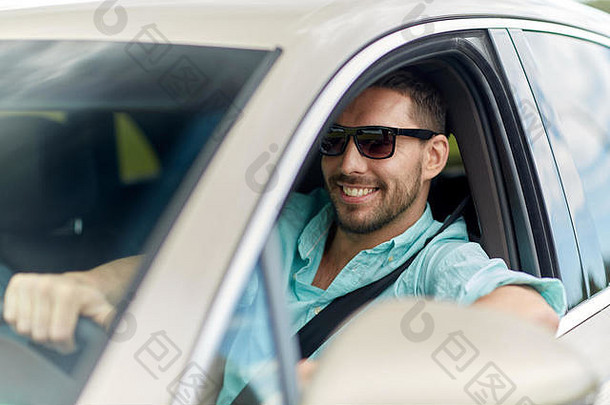 戴着墨镜开着车的快乐微笑的男人