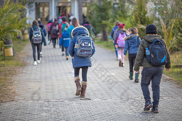 一群孩子一起上学，回到学校，冬天。