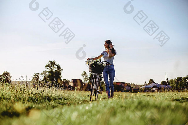 在温暖的阳光下，女孩骑着自行车和小<strong>狗</strong>在田野里散步