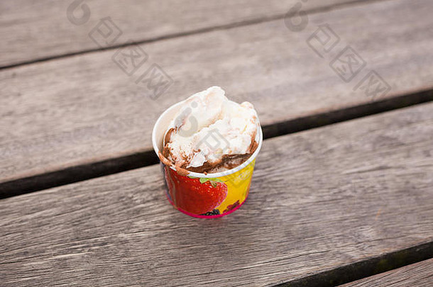 木制背景上的一杯软<strong>冰淇淋</strong>。户外咖啡馆木桌上的<strong>夏日</strong>甜点。新鲜的几勺各式<strong>冰淇淋</strong>。圣代。
