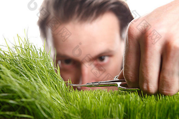 年轻人用指甲剪修剪英国的草坪