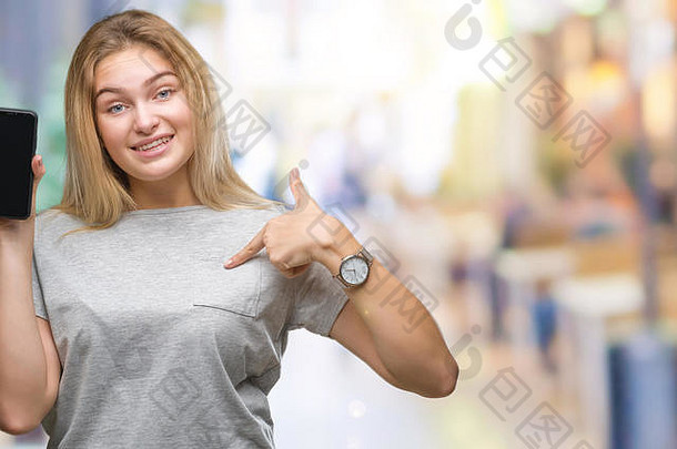 年轻的高加索人女人显示屏幕智能手机孤立的背景惊喜脸指出手指