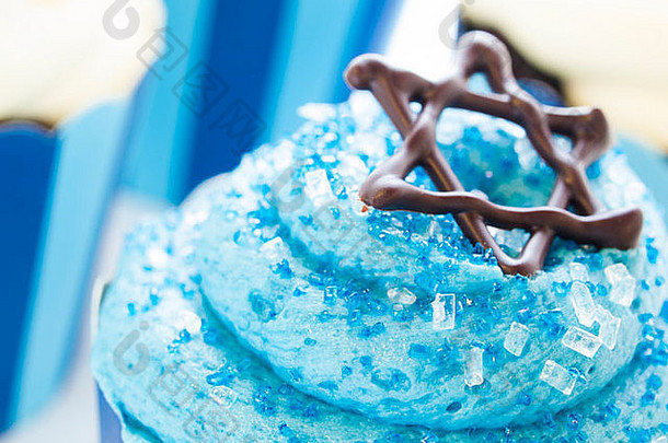 光明节用白色和蓝色糖衣装饰的美味纸杯蛋糕。