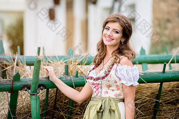 美丽的女人传统的巴伐利亚衣服有马车