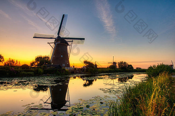 荷兰金德迪克日落时传统风车的景色。该系统由19台风车组成，建于1740年左右，是联合国教科文组织的遗产