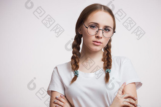 戴眼镜的年轻可爱的女学生肖像，白色背景上的t恤，带有复印空间。情感、肖像、魅力、概念