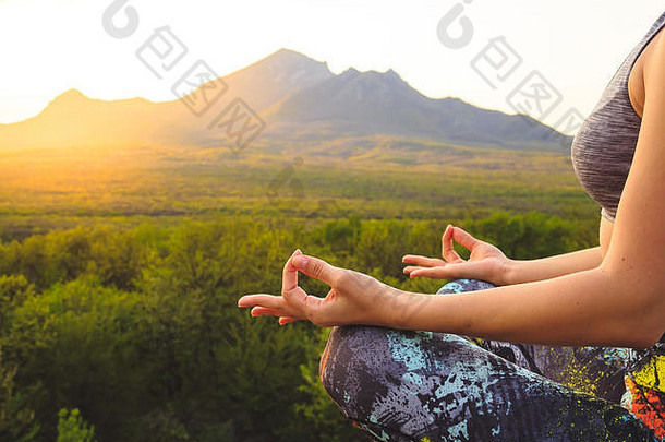 年轻的女人练习瑜伽普拉提日落日出美丽的山位置