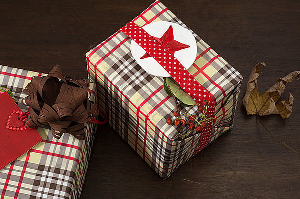 礼物用方格纸包裹，木质背景上带有红星标签的点丝带