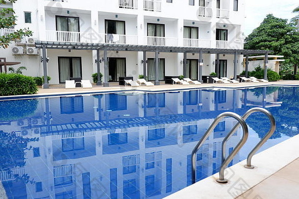 美丽的酒店，休息椅和蓝色的游泳池