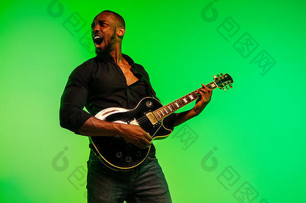 年轻的非裔美国人<strong>音乐</strong>家玩吉他明星梯度green-yellow背景概念<strong>音乐</strong>爱好节日露天快乐的有吸引力的的家伙即兴创作唱歌首歌