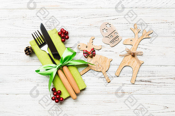 餐巾纸上<strong>新年</strong>用具的俯视图，带有节日装饰和木制背景上的驯鹿。圣诞晚餐概念的特写镜头。